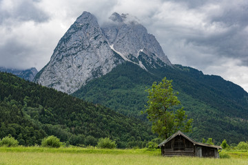 Fototapeta na wymiar Wooden hut near Zugspitze, the highest mountain of Germany at the Bavarian Alps