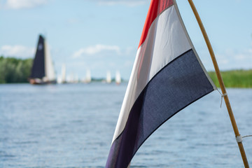 Dutch Flag with Sailboats on a Lake in the Background