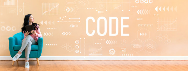 Code with young woman holding a tablet computer in a chair