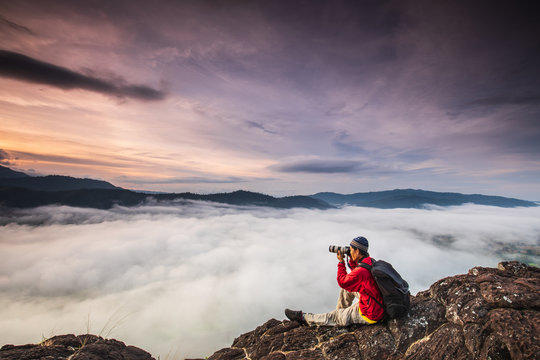 The man are taking photos  the sea of mist on high mountain in Nakornchoom, Phitsanulok province, Thailand.