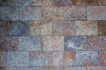 Red gray blue marble tile on the wall. natural surface texture.