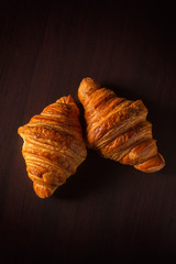 French croissant on a black background. Snapshot food in a low key.