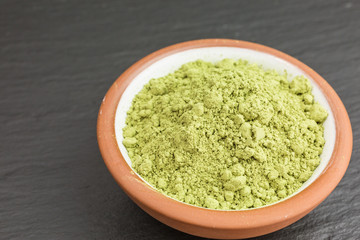 bowl of green matcha tea powder