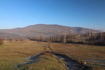 frost on the grass plain in front of the mountains