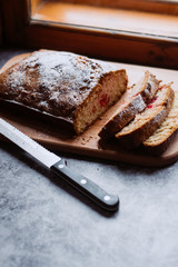 Homemade traditional sweet  cherry pie sprinkled with sugar powder. Cut cake