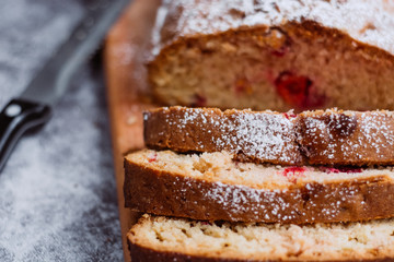 Homemade traditional sweet  cherry pie sprinkled with sugar powder. Cut cake