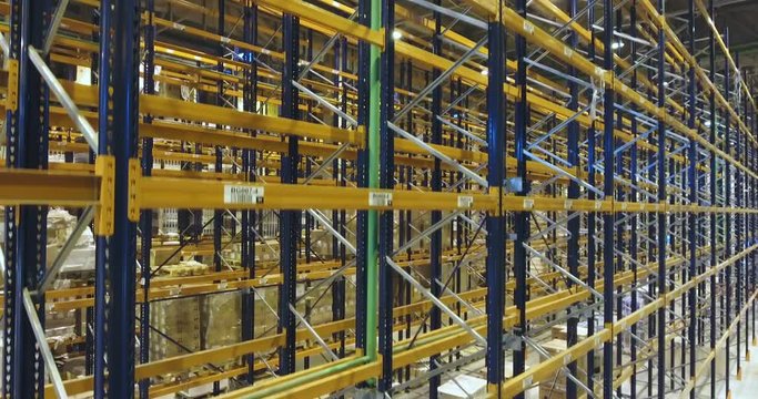Warehouse, hangar storage racks and shelves industrial logistic delivery. Large logistics hanga warehouse. Shooting between metal shelves for storing goods in a huge logistics center.