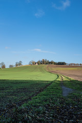 Fototapeta na wymiar Winding country path towards church on a hill
