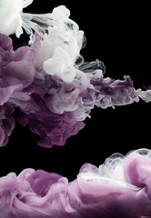 ?olor Ink purple and white drop in water. Abstract background black isolated.