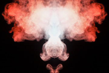Mystical pattern of colored smoke of red and white in the shape of a head creating a feeling of fear on a black isolated background from a horror movie.