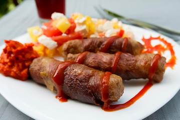 Chevapchichi. Meat sausages with vegetable salad, ketchup and adjika on white plate. Dish of Balkan cuisine.