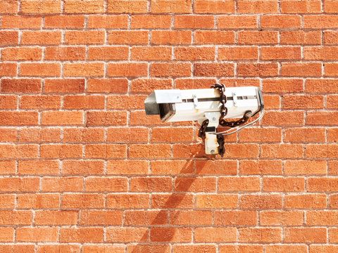 Surveillance camera on red brick wall