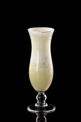 Glass of fresh melon milkshake isolated at black background.