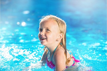Fototapeta na wymiar Beautiful little girl sunning at the pool