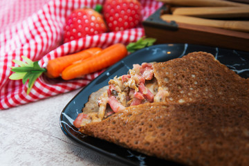 Black wheat and wheat galette topped with cooked ham and emmental cheese
