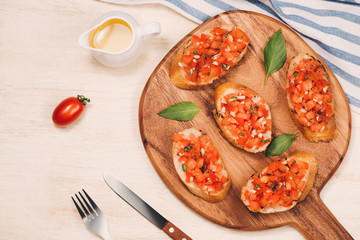 Italian bruschetta with roasted tomatoes, mozzarella cheese and herbs on a paper