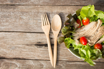 Vegetables salad with chicken on wooden background