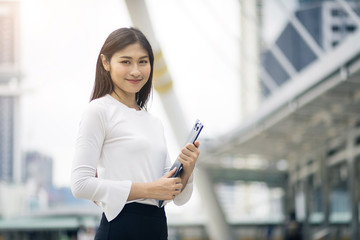 Fototapeta premium portrait of smart girl hold a folder and stand with city on background