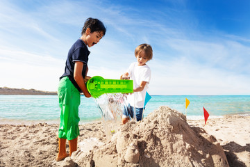 Cute boys building sand castle on the beach