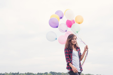 Asian girl with balloons in the field