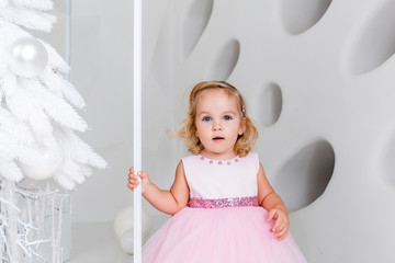 Portrait of a happy little girl Christmas. New Year's holidays. Kid in a festively decorated room with a Christmas tree.