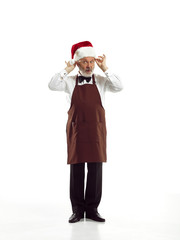 Portrait of Man in Santa Claus Costume - with a Luxurious White Beard, Santa's Hat and a Red Costume at red studio background