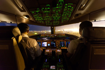 Inside cockpit on ground at an airport, both pilots are operating the airplane moving to the...
