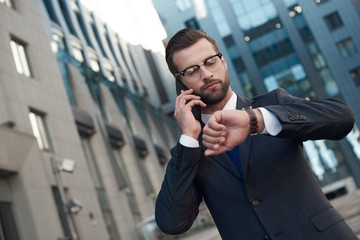 A young businessman in glasses and with a beard arranges a meeting