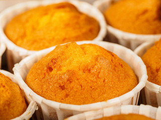 Freshly baked cinnamon mini muffins for breakfast in the morning.  Green Paper holder on a wooden background.