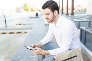 Executive Using E-Reader On Footpath