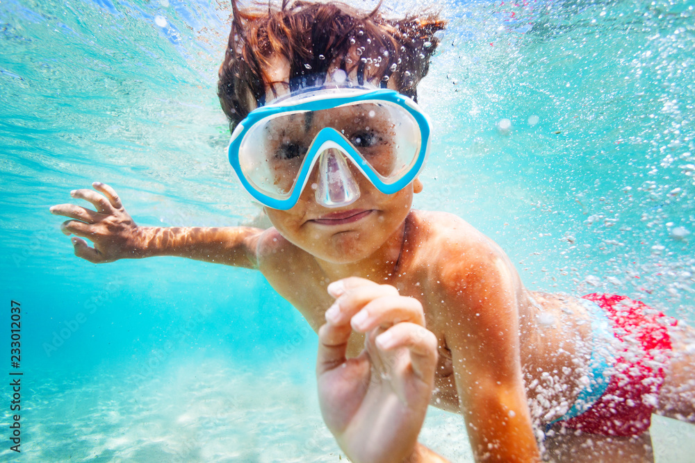 Wall mural happy boy in scuba mask swimming underwater