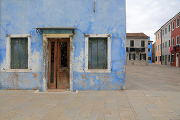Insel Burano bei Venedig: Verwitterte Hausfassade mit Blick auf bunte Häuser und Wäscheleinen