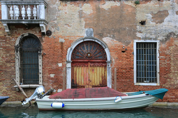 Naklejka premium Venedig bei Hochwasser: Alte verwitterte Fassade und Tor mit Boot an einem Kanal im Stadtteil Cannaregio