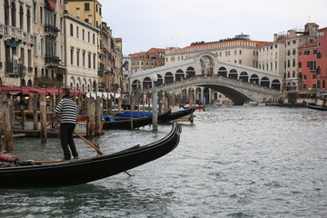 Fototapeta premium Venedig bei Hochwasser: Palast, Gondeln und Boote am Canal Grande vor der Rialtobrücke