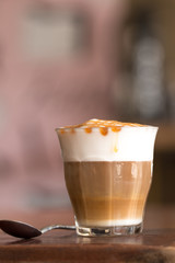 Latte macchiato coffee on wooden desk in coffee shop