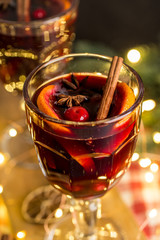 Christmas composition with spicy mulled wine, led lights and pine cones on dark background