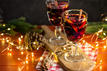 Christmas composition with spicy mulled wine, led lights and pine cones on dark background