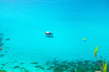 Fototapeta na wymiar Fishing yacht and rubber boat in Capo Vaticano lagoon, Calabria, Italy