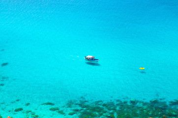 Fishing yacht and rubber boat in Capo Vaticano lagoon, Calabria, Italy
