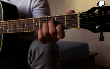 Close up on a male hand playing acoustic guitar