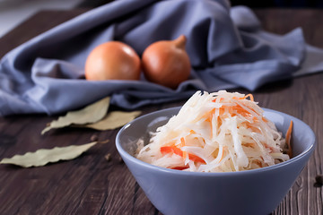 Sauerkraut in gray bowl. The concept of fermented products.