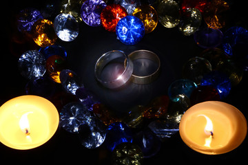 silver and gold ring, candles, a heart-shaped colored crystals