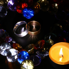silver and gold ring, candles, a heart-shaped colored crystals