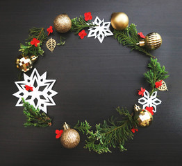 Christmas wreath frame on dark wooden background. Minimalist trend design. Space for text.