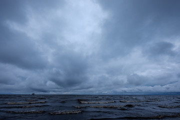 dirty beach by the sea with storm clouds above