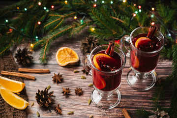 Christmas mulled wine with orange, spices on a wooden table. Traditional alcoholic hot drink