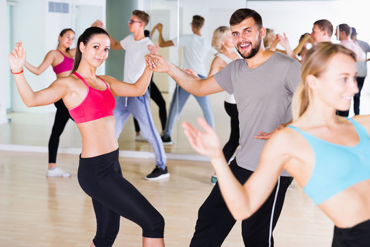 dancing couples of men and women learning swing