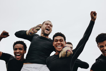 Football players screaming in joy celebrating a win