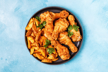 Fried chicken legs with potatoes.