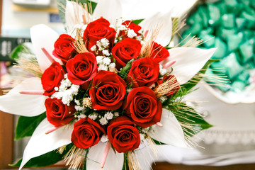 coloratissimo mazzolino di rose rosse poggiato su un banco 